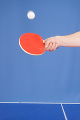 Playing table tennis. Close-up of hand serving a table tennis ba