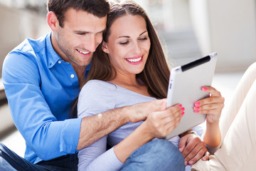 Couple using digital tablet outdoors