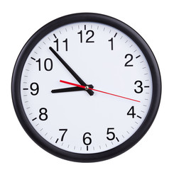 Round wall clock shows five to nine