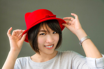 Thai girl is wearing her red hat showing cute gesture