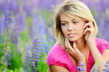 The beautiful woman in the field with lupin