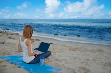 Yang woman with laptop by the ocean
