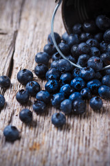 Some Blueberries in a small Bucket on wooden background