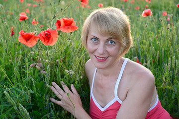 Portrait of the woman of average years with red poppies