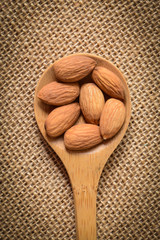 Almonds in a Wodden Spoon on a Burlap Background