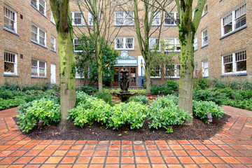 Fototapeta na wymiar City apartment building main front yard with spring landscape.