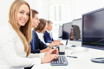 lächelnde junge Frau bei der Teamarbeit am Computer