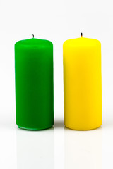 two candles of different colors on a white background