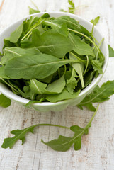 rucola in a glass bowl isolated on white background