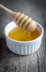 Honey bowl with dipper and flowing honey