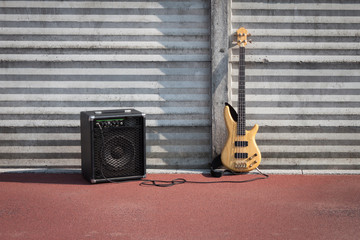 Bass guitar and amplifier against a wall