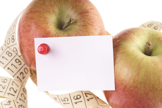 zwei Äpfel mit Maßband und leerem Zettel