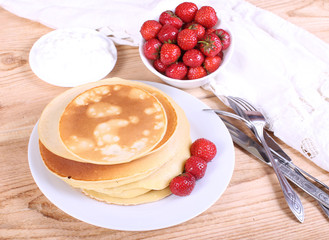 pancakes on a plate with berries and cream