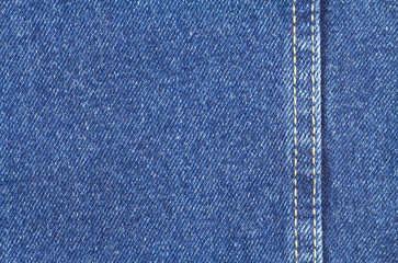 Texture of blue jeans fabric with yellow stitching on right side