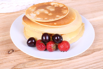 pancakes with ripe berries. on a wooden table.