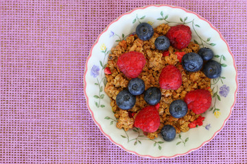 Breakfast cereal with fresh raspberries and blueberries