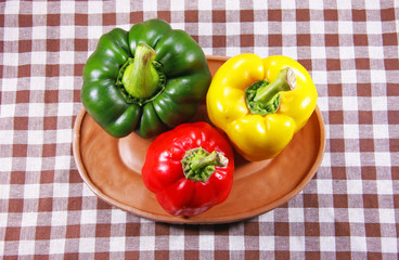 green yellow and red sweet pepper in clay dish