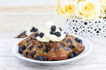 Delicious cake with blueberries, decorated with cream and fresh