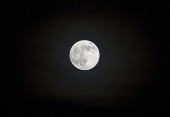 Naklejka na ściany i meble Close view of a full moon over a black background.