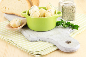 Tender young potatoes with sour cream and herbs in pan