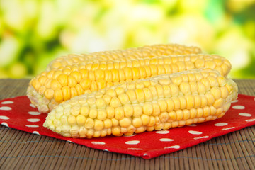 Fresh corn on bamboo mat, on wooden background