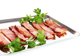 Fried bacon on metal tray isolated on white