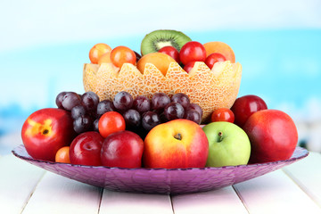 Assortment of juicy fruits on wooden table, on bright