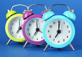 Colorful alarm clock on blue background