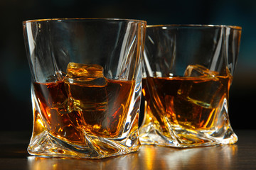 Glasses of whiskey, on bright background