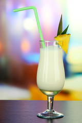 Pina colada drink in cocktail glass, on bright background