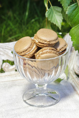 Parisian macarons in glass goblet. Garden party setting