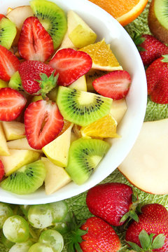 Useful fruit salad of fresh fruits and berries in bowl close-up