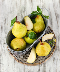 Pears in basket on braided tray on wooden table