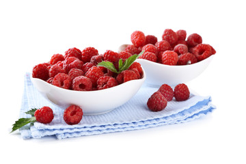 Ripe sweet raspberries in bowls, isolated on white