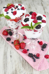 Natural yogurt with fresh berries on wooden background