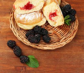 Tasty donuts with berries on wooden table