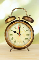 Alarm clock on table on light background