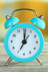 Alarm clock on table on bright background