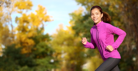 Female runner running in fall forest outside