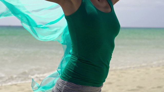 Smiling woman with pareo standing on the beach, slow motion shot