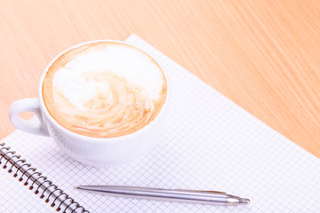 Open blank note book with coffee cup on table