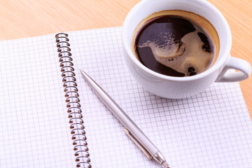 Open blank note book with coffee cup on table