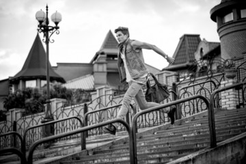 Fototapeta premium black-and-white photo of a guy with a bag of fashion, running up