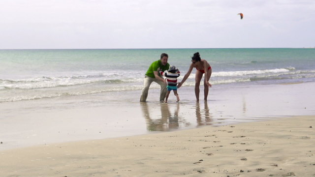 Little boy running to parents on the beach, slow motion shot at 