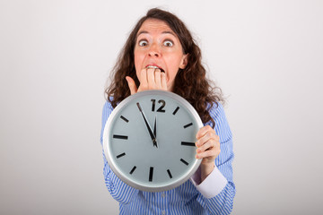 Die junge Gesch&auml;ftsfrau h&auml;lt eine gro&szlig;e Uhr in den H&auml;nden