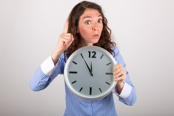 Die junge Gesch&auml;ftsfrau h&auml;lt eine gro&szlig;e Uhr in den H&auml;nden