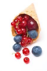 Assorted fresh seasonal berries in a waffle cone isolated