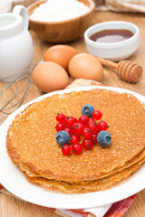 crepes with fresh berries and ingredients for baking close-up