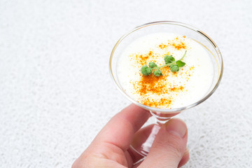 glass of tomato panna cotta with pepper and yogurt in hand
