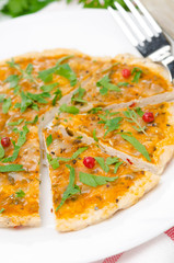 sliced ​​chicken pizza with tomato sauce, cheese and herbs